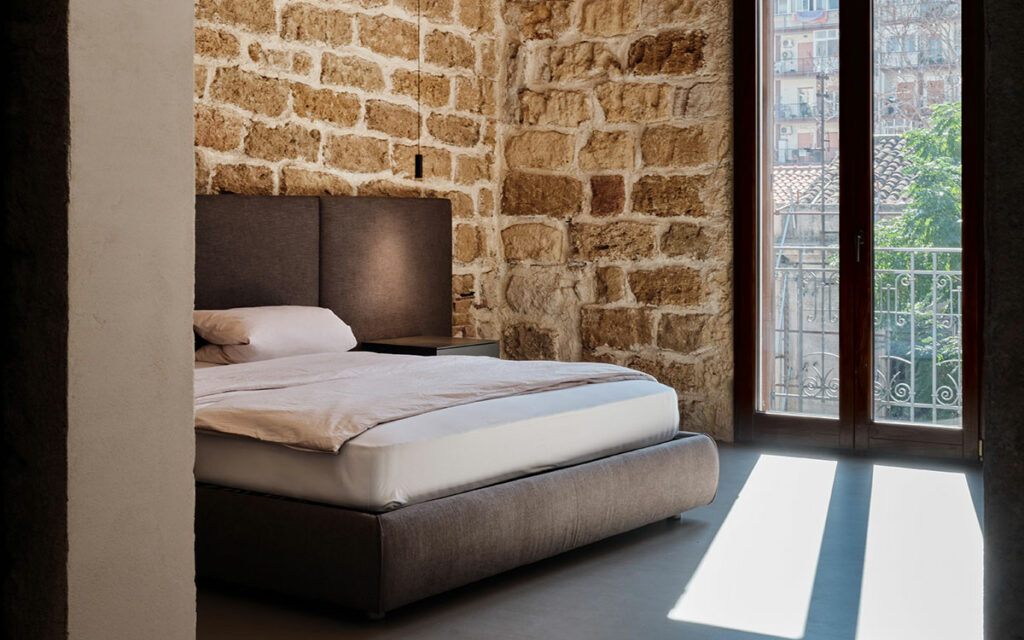 Camera da letto luninosa con muri in pietra